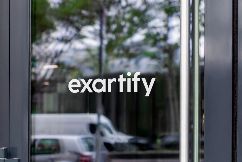 The Exartify logo on a glass shop door